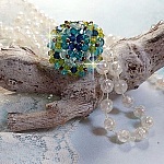 Bague Espérance montée avec toupies Aquamarine AB, Blue Zircon, Capri Blue, Olivine AB, Cristal avec des facettes entrelacées avec des rocailles. Elle s’adaptera parfaitement à votre doigt